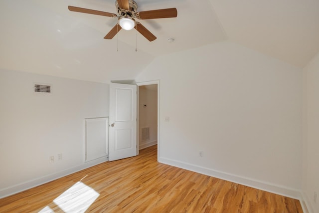 empty room featuring ceiling fan, vaulted ceiling, and light hardwood / wood-style flooring