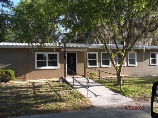 312 W Margurite St, Perry, FL 32347 - ranch-style home featuring concrete block siding and a metal roof