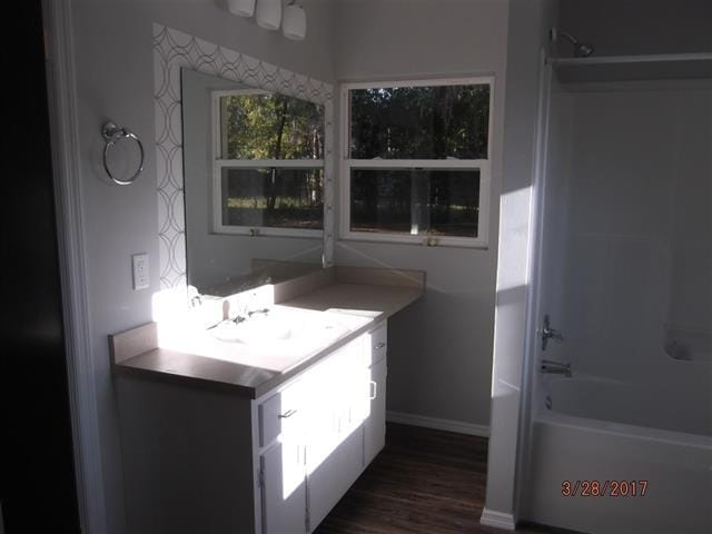 312 W Margurite St, Perry, FL 32347 - bathroom with vanity, shower / bath combination, and wood finished floors