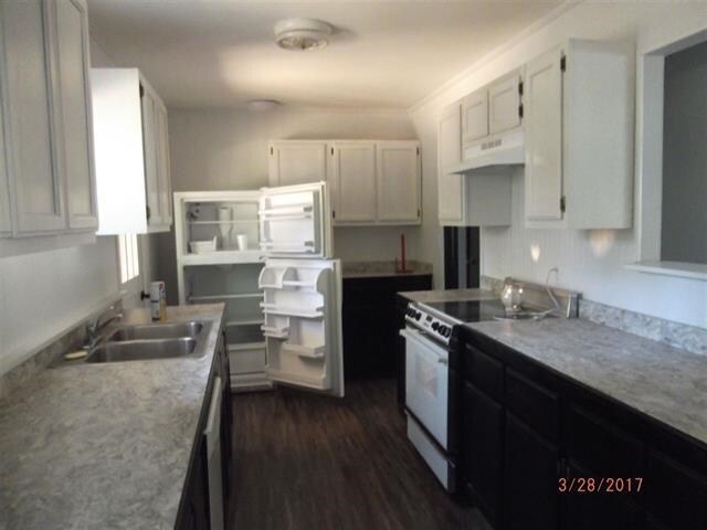 312 W Margurite St, Perry, FL 32347 - kitchen with white electric range oven, under cabinet range hood, dark wood-type flooring, light countertops, and white cabinets