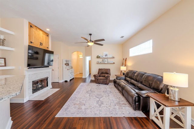 1842 Acorn Ridge Trl, Tallahassee, FL 32312 - living area with arched walkways, a ceiling fan, dark wood-style floors, a tile fireplace, and baseboards