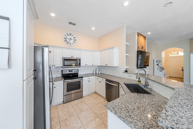 1842 Acorn Ridge Trl, Tallahassee, FL 32312 - kitchen featuring appliances with stainless steel finishes, a sink, a peninsula, decorative backsplash, and recessed lighting