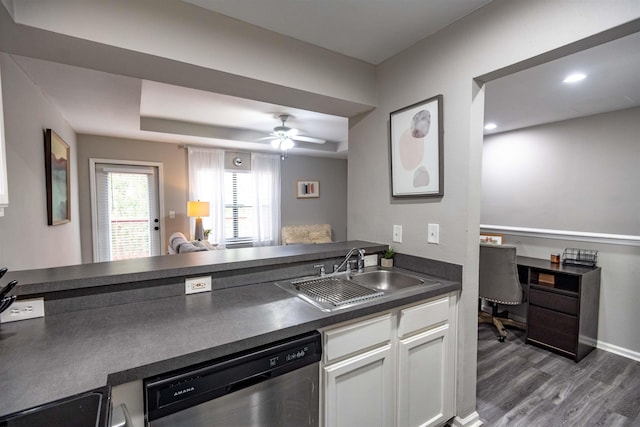 kitchen featuring white cabinetry, dishwasher, sink, a tray ceiling, and dark wood-type flooring