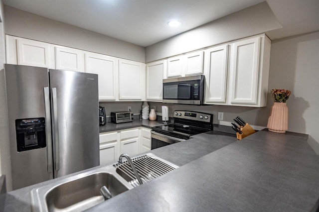 kitchen with stainless steel appliances, white cabinetry, and sink