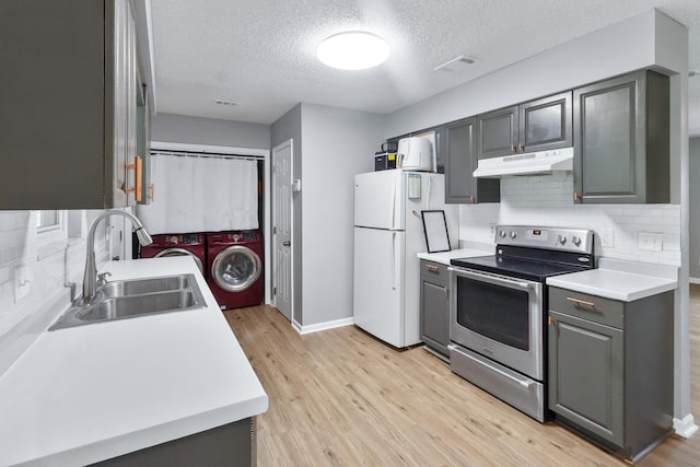 11124 Bexhill Ln, Tallahassee, FL 32317 - kitchen with stainless steel range with electric cooktop, freestanding refrigerator, independent washer and dryer, under cabinet range hood, and a sink
