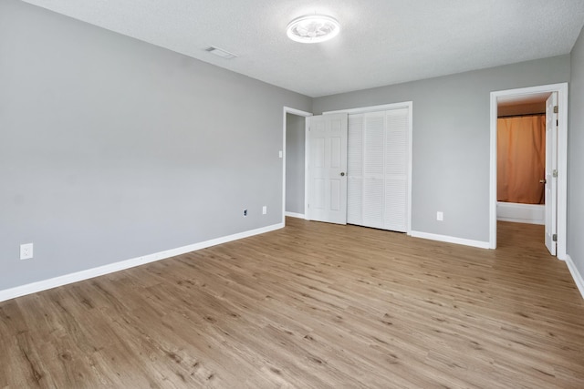 11124 Bexhill Ln, Tallahassee, FL 32317 - unfurnished bedroom featuring ensuite bathroom, a closet, visible vents, wood finished floors, and baseboards