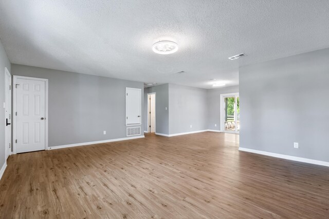 11124 Bexhill Ln, Tallahassee, FL 32317 - empty room featuring visible vents, baseboards, wood finished floors, and a textured ceiling
