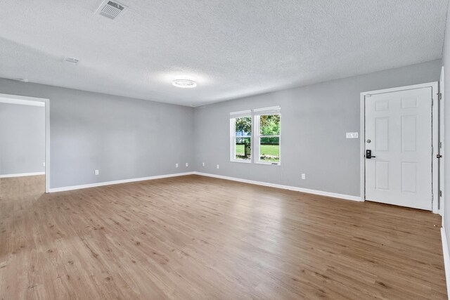11124 Bexhill Ln, Tallahassee, FL 32317 - unfurnished living room with visible vents, a textured ceiling, baseboards, and wood finished floors
