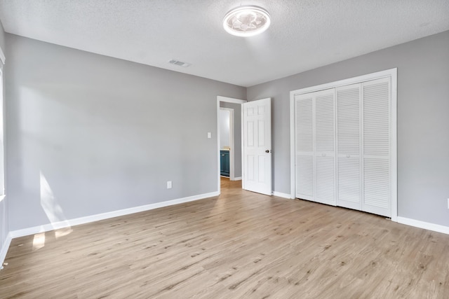 11124 Bexhill Ln, Tallahassee, FL 32317 - unfurnished bedroom featuring a closet, baseboards, light wood finished floors, and a textured ceiling
