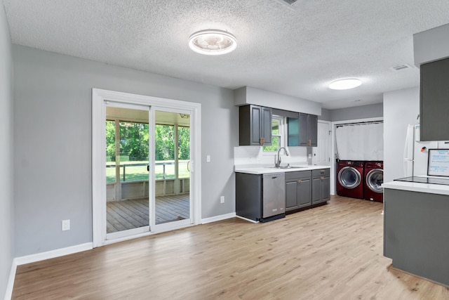 11124 Bexhill Ln, Tallahassee, FL 32317 - kitchen with washer and dryer, light countertops, a textured ceiling, light wood finished floors, and gray cabinetry