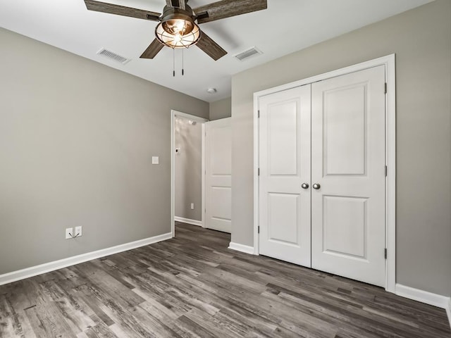 unfurnished bedroom featuring ceiling fan, dark hardwood / wood-style flooring, and a closet