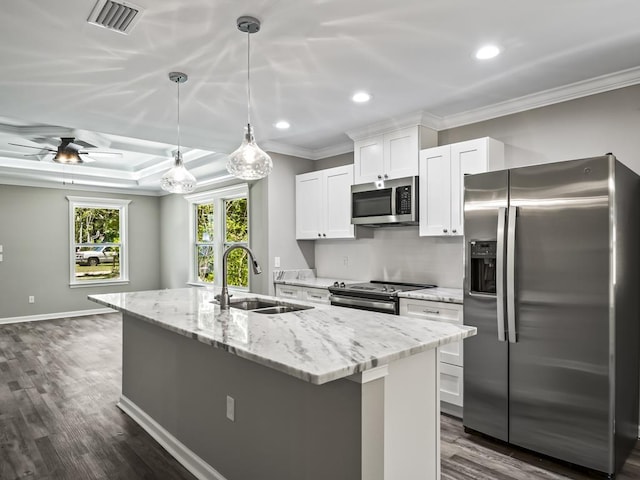 kitchen with sink, hanging light fixtures, a center island with sink, appliances with stainless steel finishes, and white cabinets