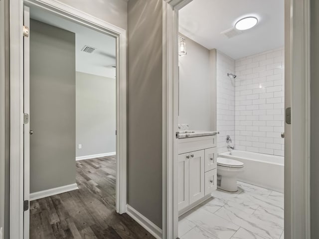 full bathroom featuring tiled shower / bath combo, vanity, and toilet