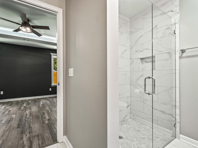 bathroom with hardwood / wood-style flooring, an enclosed shower, and ceiling fan