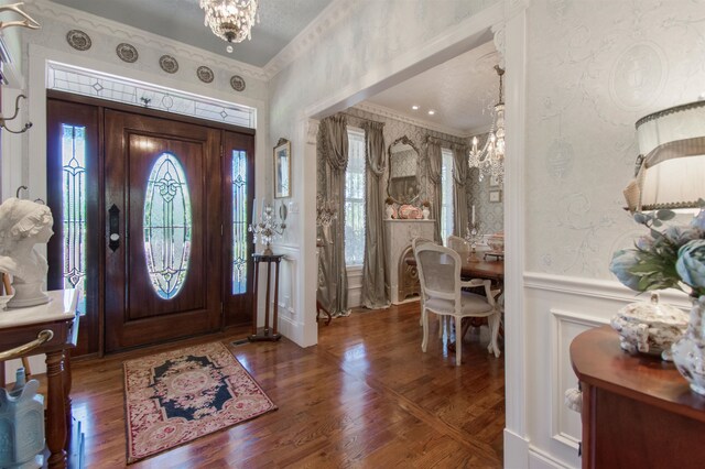 2460 Canopy Ln, Perry, FL 32347 - entrance foyer featuring a chandelier, crown molding, a wainscoted wall, wood finished floors, and a decorative wall