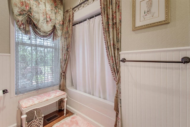 2460 Canopy Ln, Perry, FL 32347 - bathroom with a textured wall, shower / bath combo with shower curtain, and wainscoting