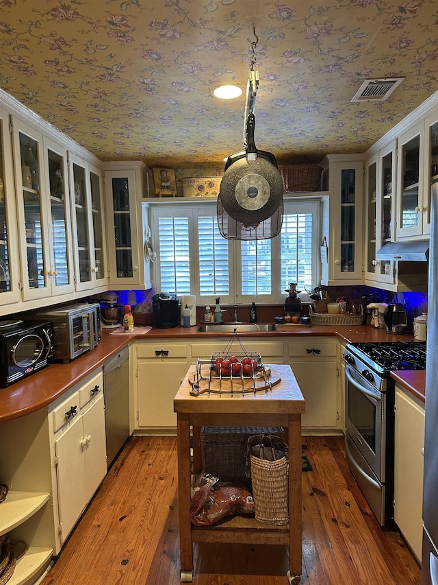 kitchen featuring white cabinets, light hardwood / wood-style floors, sink, and appliances with stainless steel finishes