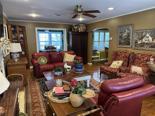 living room with ceiling fan, wood-type flooring, and ornamental molding