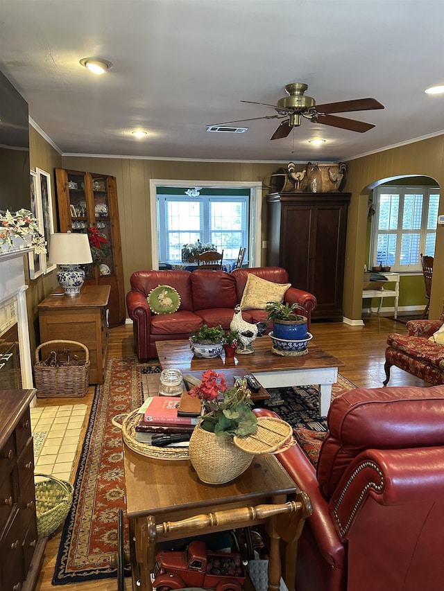 living room with ceiling fan, ornamental molding, and light hardwood / wood-style flooring