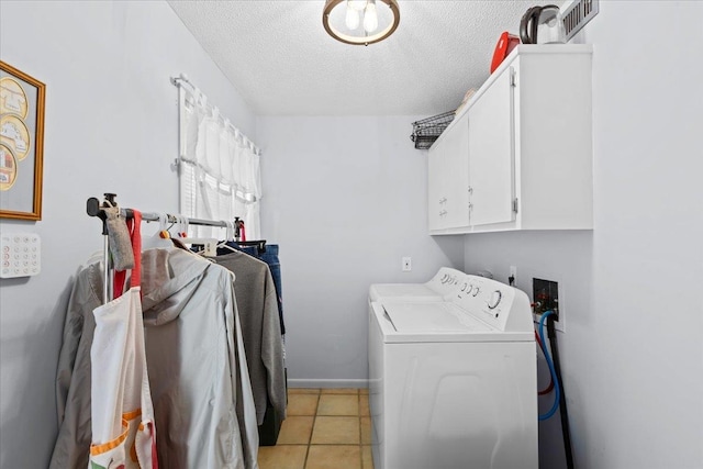 laundry area with light tile patterned flooring, cabinets, independent washer and dryer, and a textured ceiling