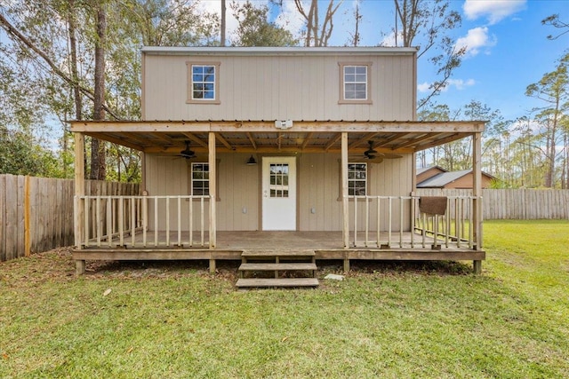 rear view of property featuring ceiling fan, a yard, and a deck