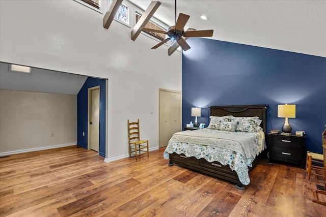 bedroom featuring ceiling fan, high vaulted ceiling, and wood-type flooring