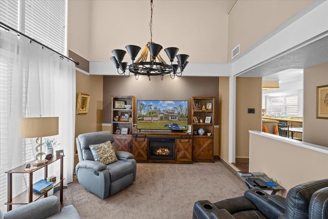 living room featuring a towering ceiling, carpet floors, and a notable chandelier