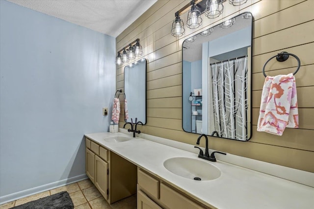 bathroom featuring a textured ceiling, vanity, tile patterned floors, and wood walls