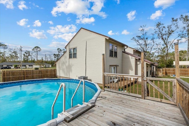 view of pool with cooling unit and a deck