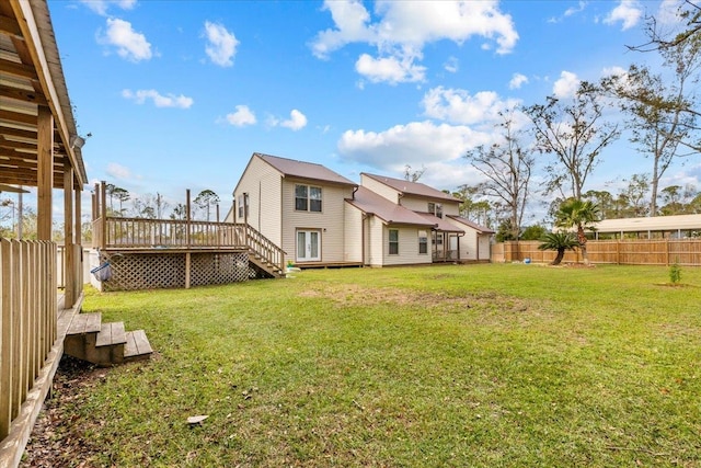 rear view of property featuring a yard and a deck