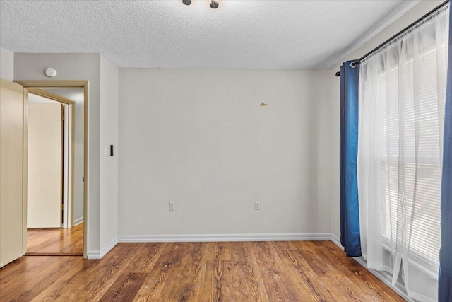 empty room featuring wood-type flooring and a textured ceiling