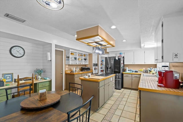 kitchen featuring tile countertops, white cabinetry, stainless steel appliances, and a textured ceiling