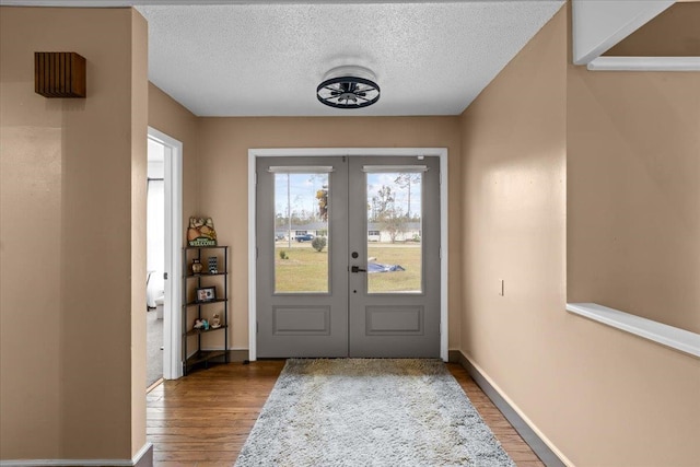 doorway to outside featuring french doors, dark hardwood / wood-style flooring, and a textured ceiling