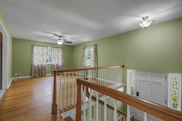 2307 Spoonwood Dr, Tallahassee, FL 32303 - hall with an upstairs landing, wood finished floors, a textured ceiling, and baseboards