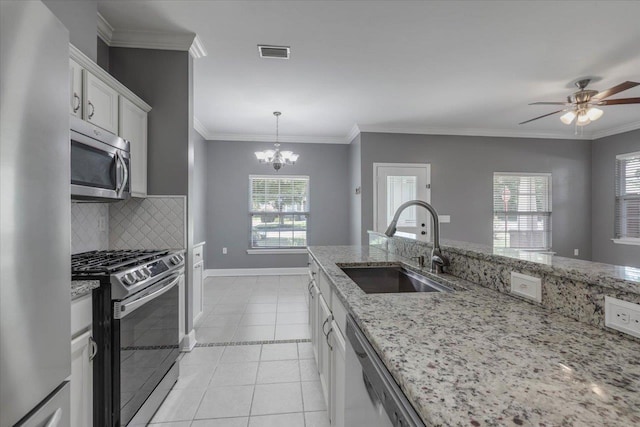 1224 Athens Ct, Tallahassee, FL 32305 - kitchen featuring stainless steel appliances, a sink, decorative backsplash, a chandelier, and light stone counters