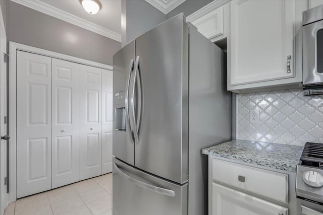 1224 Athens Ct, Tallahassee, FL 32305 - kitchen featuring stainless steel appliances, crown molding, light tile patterned floors, white cabinets, and decorative backsplash