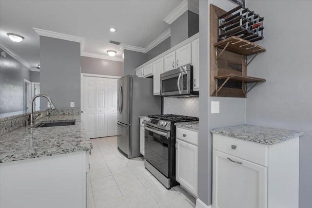 1224 Athens Ct, Tallahassee, FL 32305 - kitchen featuring appliances with stainless steel finishes, a sink, white cabinetry, crown molding, and backsplash