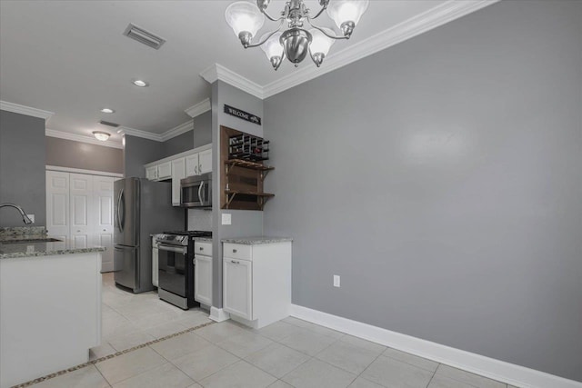 1224 Athens Ct, Tallahassee, FL 32305 - kitchen featuring appliances with stainless steel finishes, ornamental molding, white cabinetry, a chandelier, and light tile patterned floors