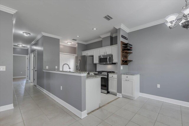 1224 Athens Ct, Tallahassee, FL 32305 - kitchen featuring stainless steel appliances, crown molding, white cabinetry, a chandelier, and backsplash