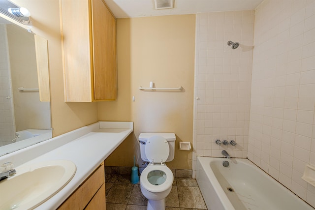 full bathroom featuring toilet, tiled shower / bath, and vanity