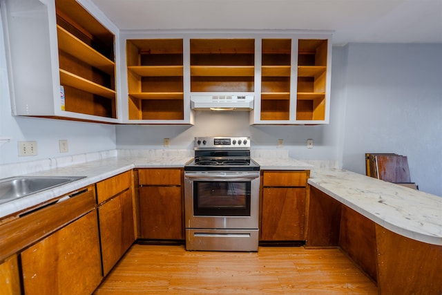 kitchen with light hardwood / wood-style floors, stainless steel electric range oven, and kitchen peninsula