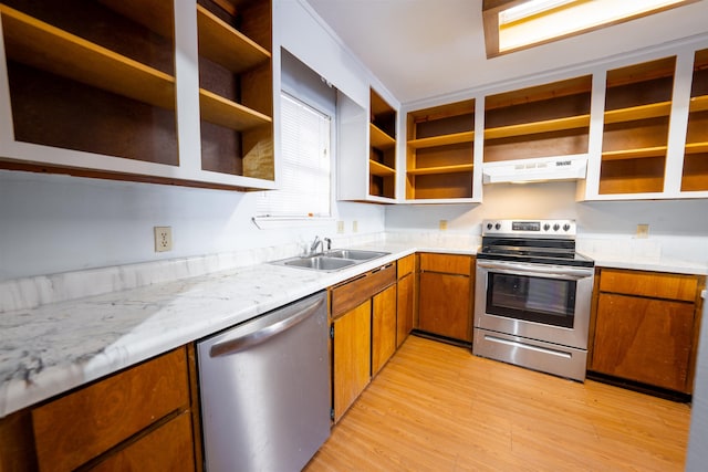 kitchen featuring light wood-type flooring, light stone countertops, stainless steel appliances, and sink