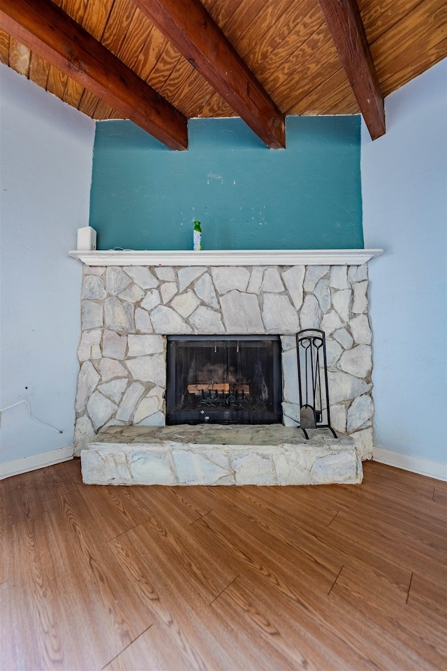 room details featuring beam ceiling, wooden ceiling, a stone fireplace, and hardwood / wood-style flooring