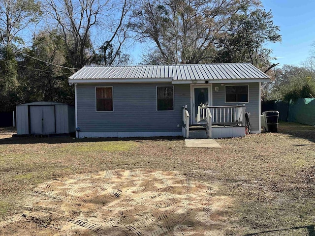 view of front of home featuring a storage unit and a front yard