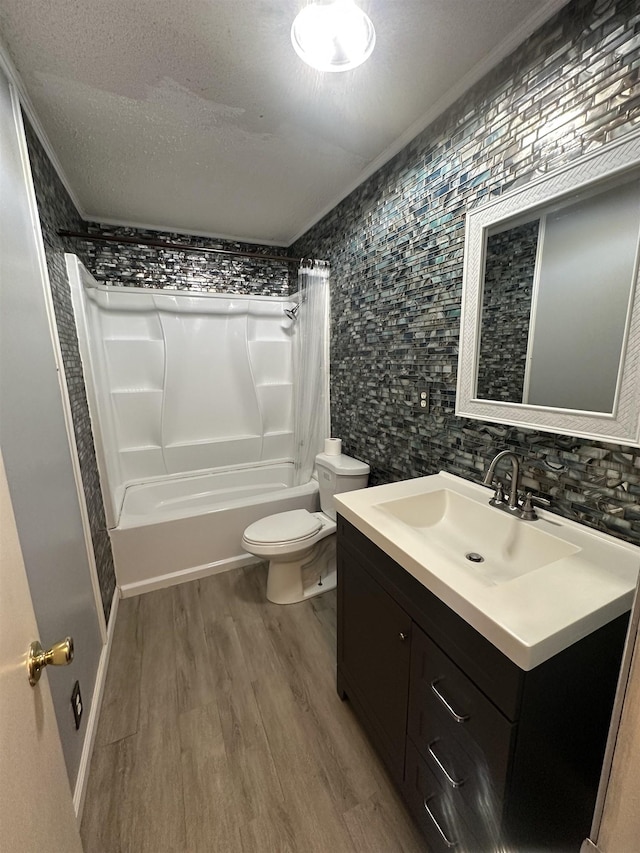 full bathroom with shower / tub combo with curtain, toilet, a textured ceiling, vanity, and hardwood / wood-style floors