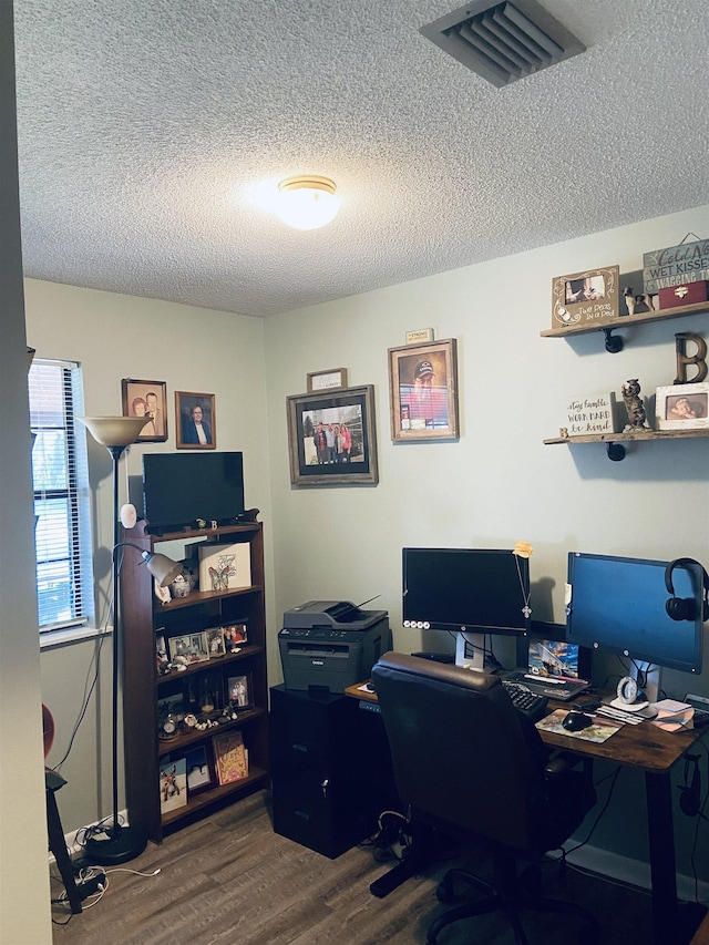 home office with wood-type flooring and a textured ceiling