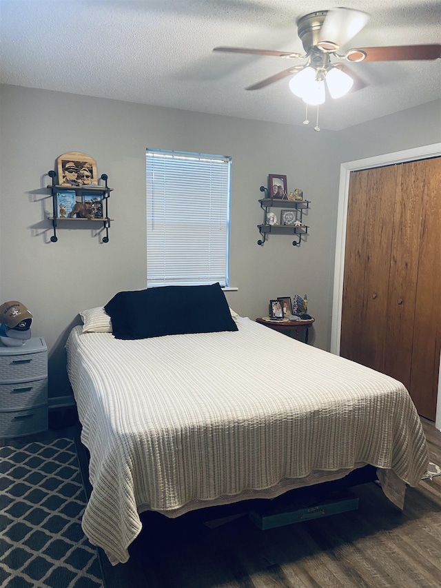 bedroom with ceiling fan, a closet, wood-type flooring, and a textured ceiling