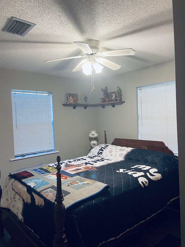 bedroom with a textured ceiling and ceiling fan