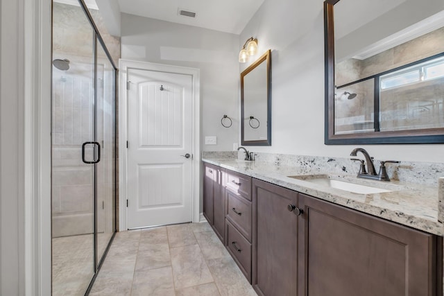 bathroom with vanity and a shower with door