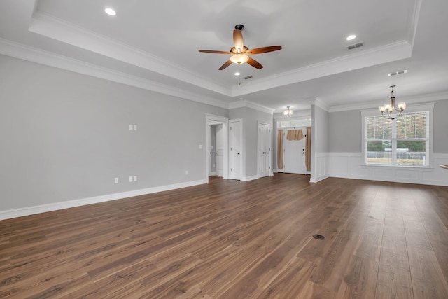 unfurnished living room with a tray ceiling, dark hardwood / wood-style flooring, ceiling fan with notable chandelier, and ornamental molding